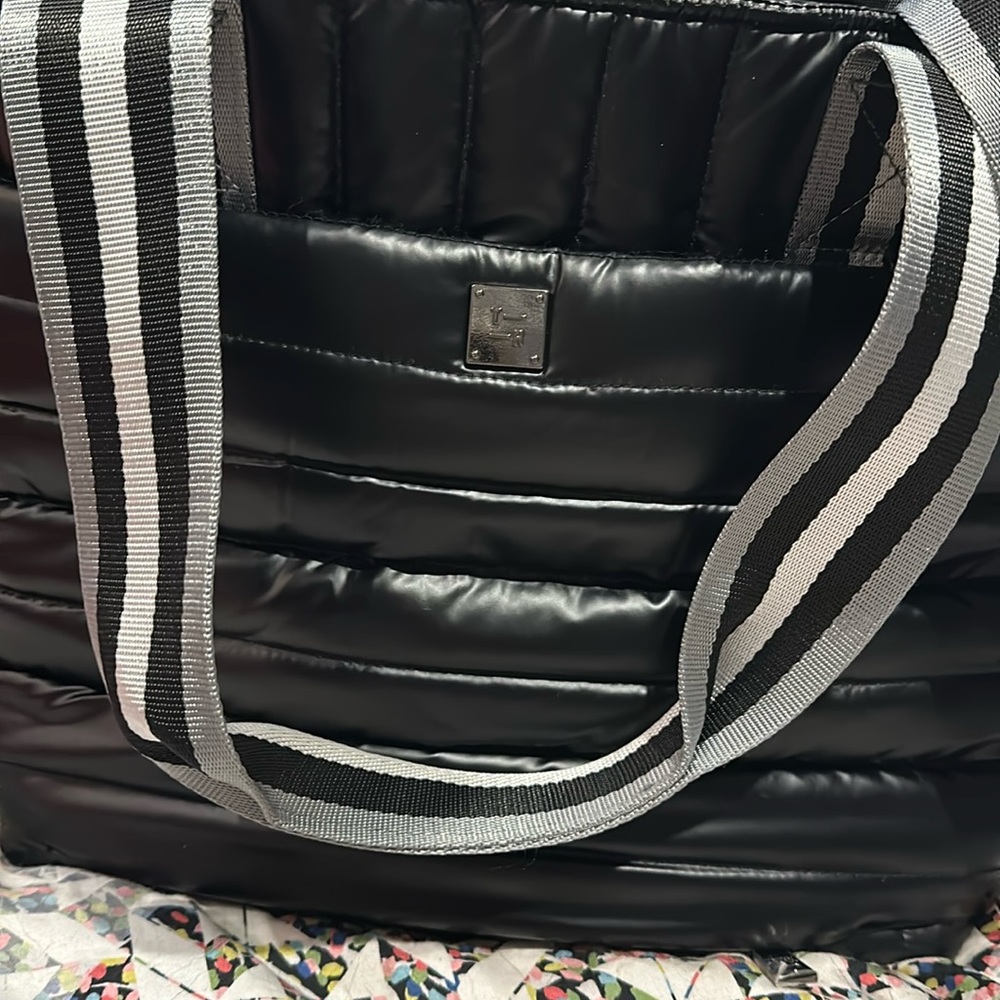 Black Think Rolyn bag. Can be used as a messenger bag. Good space.